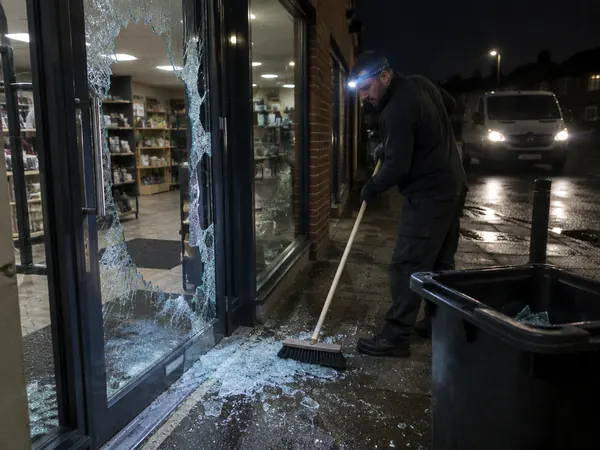 Engineer making a smashed shop door safe at night
